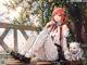 A girl sitting on a bench next to a white cat.