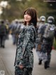 A woman in a military uniform standing in front of a line of soldiers.