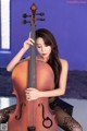 A woman sitting on a chair holding a cello.