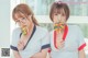 Two young women in school uniforms holding lollipops in their hands.